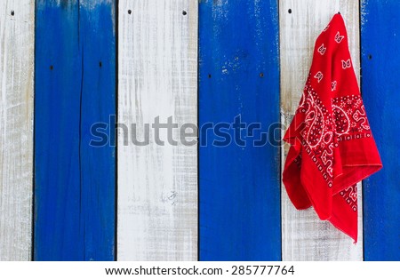 Red handkerchief or bandana hanging on blue and white rustic wooden background