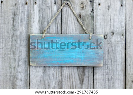 Blank rustic teal blue wooden sign hanging on old weathered wood background