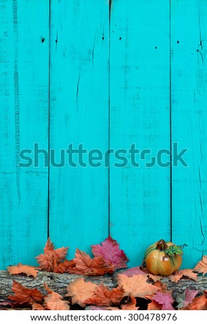 Rustic blank teal blue wood sign with fall leaves and pumpkin on log border