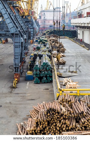 A pile of round metal pipes packed in stacks with tags size parameters for loading cranes and transport the cargo ships in the seaport and railway wagons