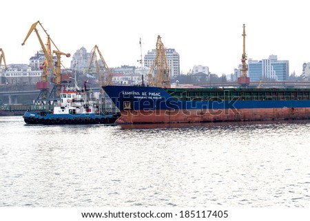 ODESSA, UKRAINE - 28 April: pilot tug towing a large sea cargo ship in the harbor of Odessa sea port on a foggy day , April 28, 2014 Odessa, Ukraine