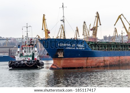 ODESSA, UKRAINE - 28 April: pilot tug towing a large sea cargo ship in the harbor of Odessa sea port on a foggy day , April 28, 2014 Odessa, Ukraine