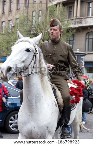 ODESSA, UKRAINE - April 10, 2014 : Victory Day World War II. Holiday parade on the streets. Horse and rider bouquet of red flowers. April 10, 2014 in Odessa , Ukraine.