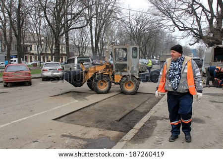 Odessa - April 3: a team of workers repairs road under the program of urban planning repairs after winter frosts that destroyed an asphalt road . April 3, 2014 in Odessa, Ukraine