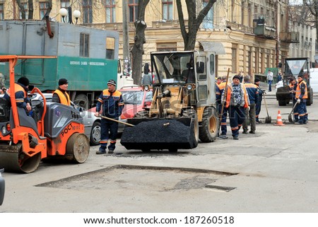 Odessa - April 3: a team of workers repairs road under the program of urban planning repairs after winter frosts that destroyed an asphalt road . April 3, 2014 in Odessa, Ukraine