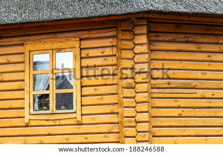 Detail of beams in the wall of the round log home built on old technology , wooden window as creative elements for natural background