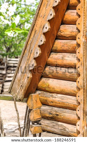 Detail of wooden beams in the wall of the round log home built on old technology as a creative element to natural background