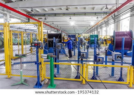 Fragment inside a modern plant producing power electric cables and optical fibers. Interior of modern production line technology obsolescence
