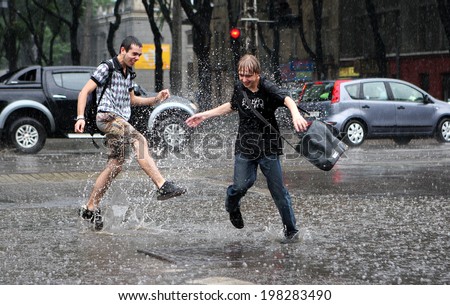 ODESSA, UKRAINE - JUNE 21: Two boys spray water in the puddles in the pouring rain on a hot day in the summer thunderstorms, June 21, 2008 in Odessa, Ukraine.