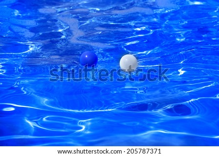 modern blue water pool with floating multi-colored plastic balls presentation opening holiday season