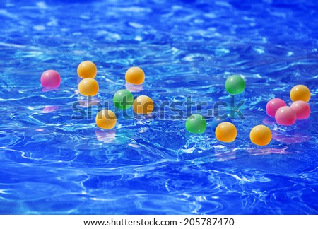 modern blue water pool with floating multi-colored plastic balls presentation opening holiday season