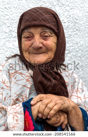 Portrait of a very lonely old woman with merry eyes and happy, happy face, with deep wrinkles multiple