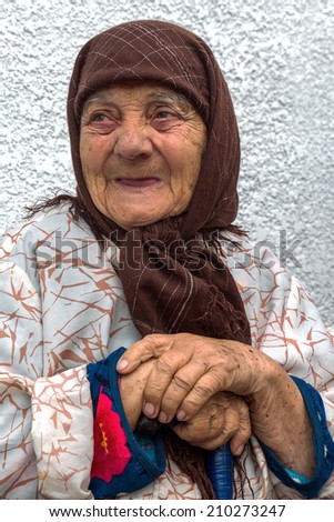 Portrait of a very lonely old woman with a worried and anxious expression, with deep wrinkles multiple