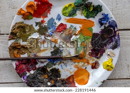Art palette and brush with lots of colors, tempera and oil paints for painting the artist at the easel. selective Focus