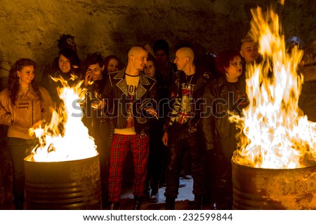 Odessa, Ukraine - November 22: Local rock band plays concert in underground catacombs dungeon destroyed building. A crowd of happy people, fans around campfire enjoy, November 22, 2014 Odessa, Ukraine