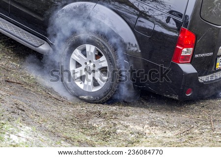 Odessa, Ukraine - December 6, 2014: Off-road 4x4 cars on the road passes sport routes in the winter mountains close-up. wheel lights up when sliding with smoke, December 6, 2014 in Odessa, Ukraine.