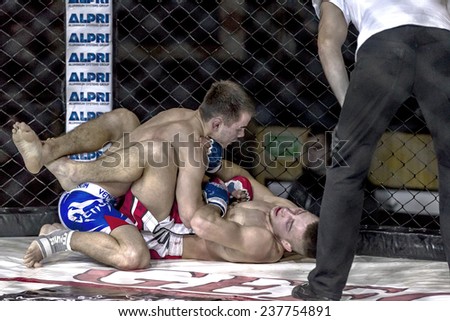 Odessa, Ukraine - December 13: Athletics MMA mixed martial arts fighters compete in the cell, causing punches and kicks. Dramatic moment of battle, December 13, 2014 in Odessa, Ukraine