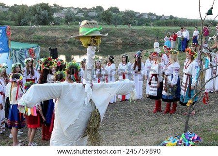 ODESSA, UKRAINE - August 24, 2014: Ukrainian people celebrating girl National Day holiday Midsummer on the river in bright robes embroidered Ukrainian cross