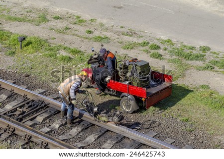 Odessa, Ukraine, August 14, 2014: Railway workers conduct repairs rails. Scraping and sanding metal seam after butt welding, flash car