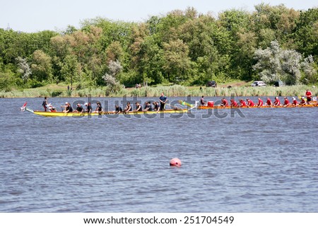 Odessa, Ukraine - May 16, 2010: Championship of Ukraine rowing among veterans. Dragon boat on the river. People rowing boat in the race in the summer