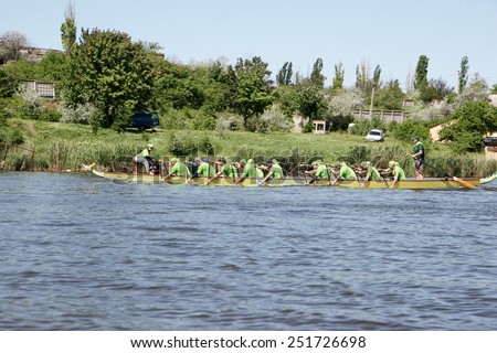 Odessa, Ukraine - May 16, 2010: Championship of Ukraine rowing among veterans. Dragon boat on the river. People rowing boat in the race in the summer