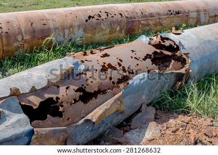 Fragments of old large water pipes. After many years of operation, corroded metal pipe destroyed. Rusty steel tube with holes metal corrosion. Selective focus.