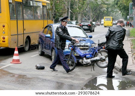 Odessa, Ukraine - October 4, 2008: Light accident between a car and a motorcycle. Bike crashed into a car. He lost control on the wet asphalt. Powered Police