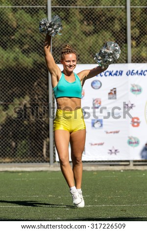 Odessa, Ukraine - September 2, 2015: Bright dynamic characteristics of a support group of women's sports team. Performance Support Group. Bright beautiful young girl in sports dance form on playground