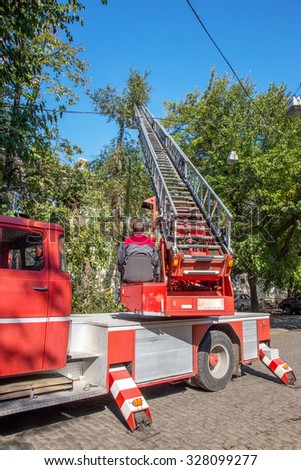 Odessa, Ukraine - October 14, 2015: Working chainsaw cut dry wood. Groundscare urban service eliminates emergency trees with the help of crane. Emergency Prevention
