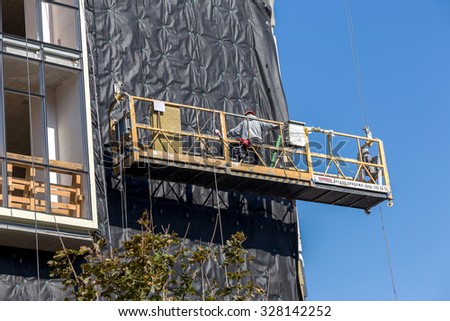 Odessa, Ukraine - October 16, 2015: Work on insulation of facades high-rise apartment building. Warming houses, house wall insulation, waterproofing the walls of house. Modern construction technology