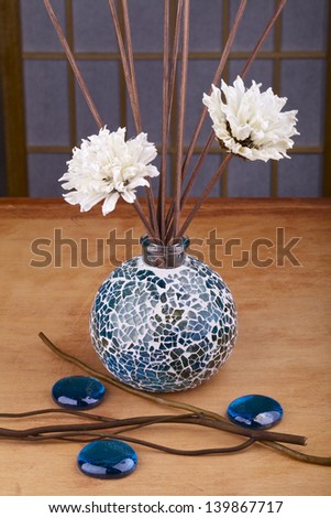 Spa decoration,a vase of flowers and fragrant twigs,pebbles on wooden table
