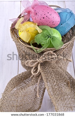 Easter decorative eggs in the basket on a light background,artificial