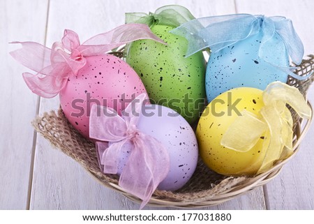Easter decorative eggs in the basket on a light background