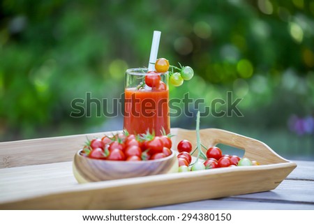 Cherry tomatoes and a glass of tomato juice.
