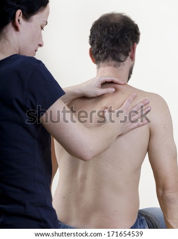 a physiotherapist treats a patient. the back is massaged