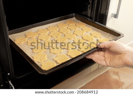 biscuits are pushed onto a baking sheet in the oven