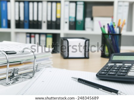 Desk in an office with files and calculator