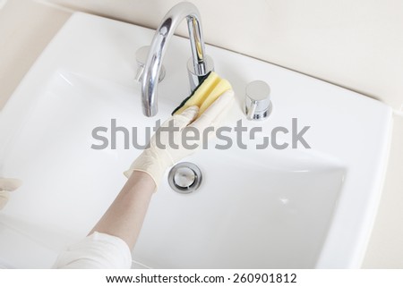 Hands with gloves Clean a Faucet with a cloth