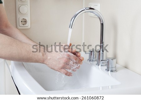 Wash hands with soap and water on a modern washstand