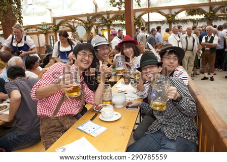 Oktoberfest, Munich, Germany, 25.09.2013, Japanese visitors to sit in the tent at the Oktoberfest and drink beer in a beer mug
