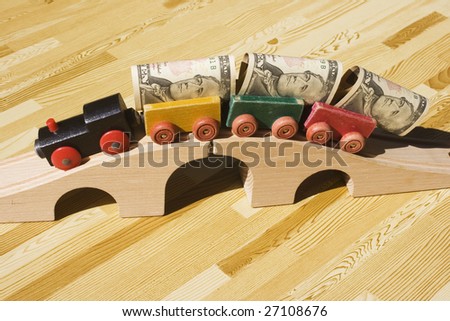 A toy train pulling a cargo of money and going over a bridge.  This picture could be a reference to \'bridging loan\',\'money delivery\', cargo.  Also, money supply and transferring money.