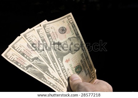 Money in hand, in a gesture as if giving or paying for something.  Its againt a black background