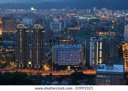 This is a view of Taipei City just after sunset.  The city is lighting up.  It\'s very urban and full of life.