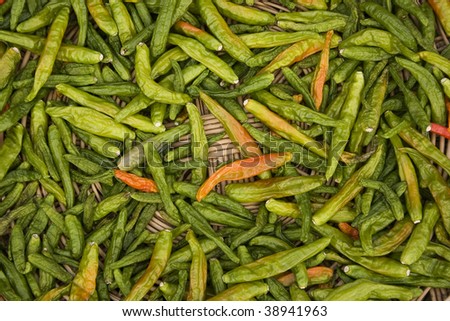 Green and some red chilies being dried outside a restaurant.