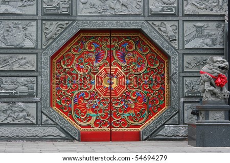 Traditional Chinese style door at a temple. This door has eight sides and is red in color.  It is decorated in traditional Chinese style.
