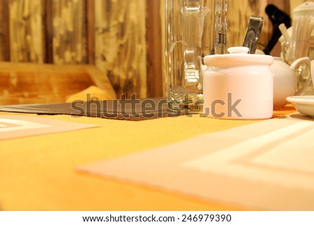 Ceramic tableware on the wooden table over bar  background