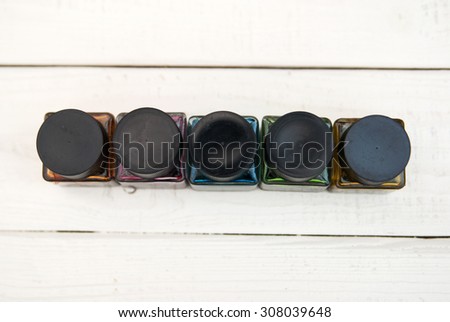 bottles of ink on a white wooden board. cans of paint on a wooden background