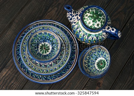 Ethnic Uzbek ceramic ware on a background of brown wood top view