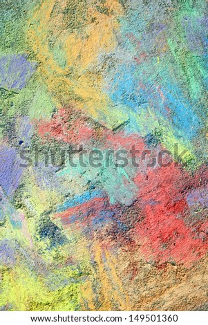 an abstract background of bright, rainbow colored sidewalk chalk smeared and drawn on the pavement