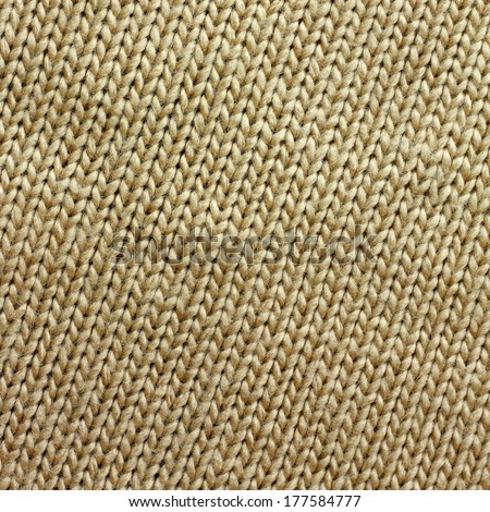 a square background of tweed tan or camel colored knit fabric is braided in lines